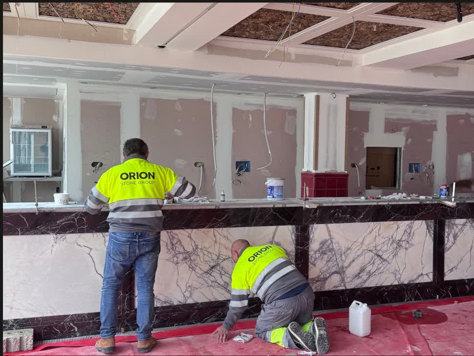 Una barra entera. Dos operarios de la casa montando el frente pieza a pieza.