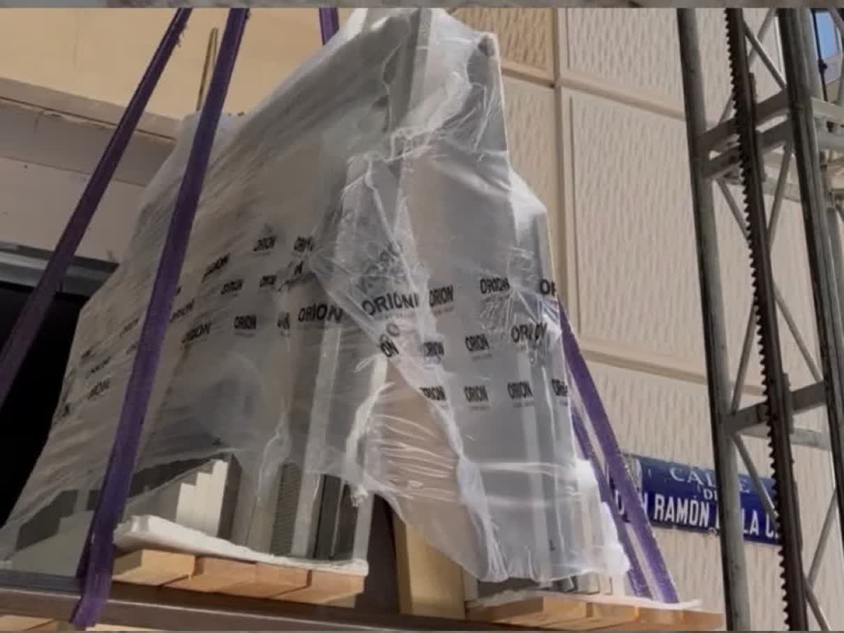 Llega a la obra. Embalada y sobre su palé, subiendo por la fachada.