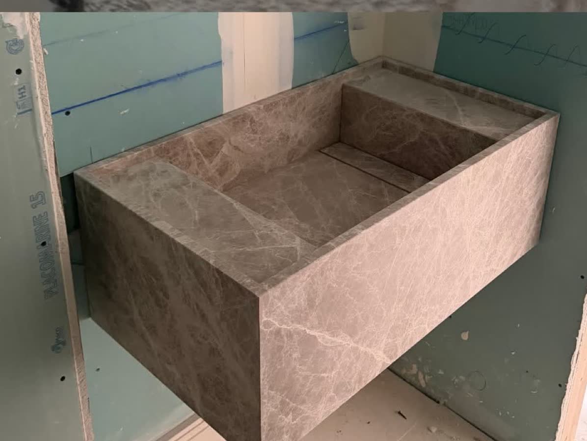 El lavabo, ya colgado. Macizo y de una pieza, esperando a que la obra acabe a su alrededor.